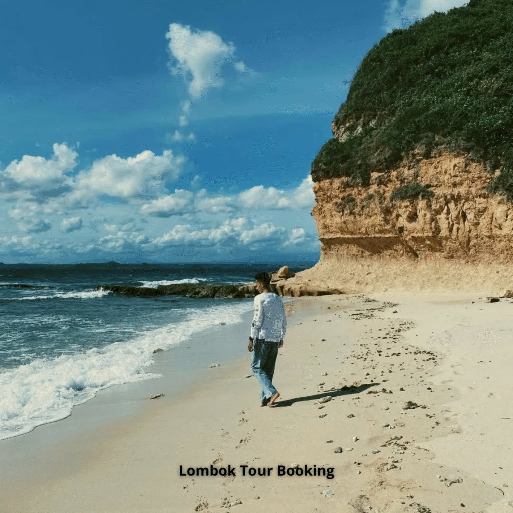 Pemandangan Pantai Surga Lombok dengan air biru jernih dan pasir putih dari atas tebing